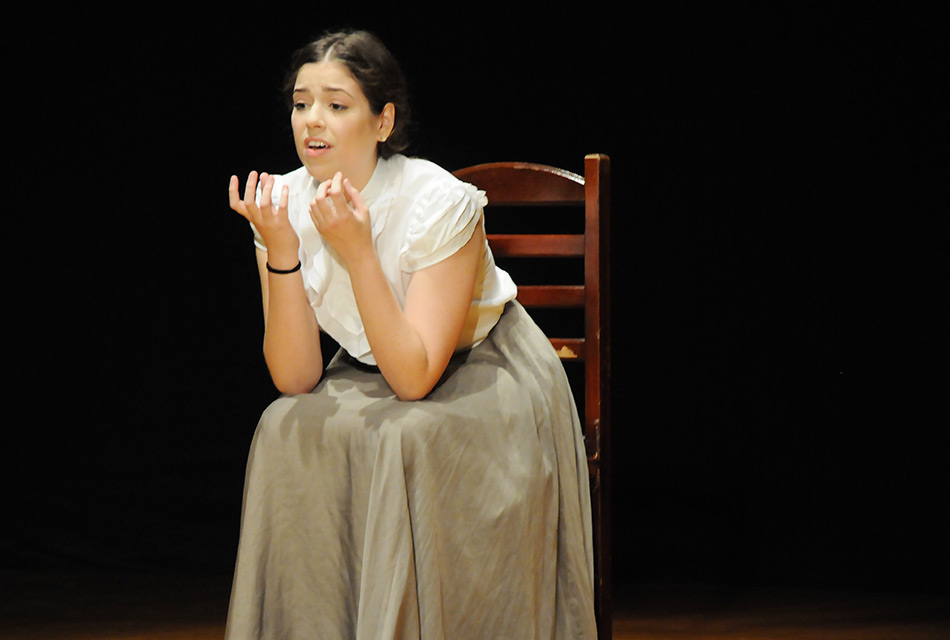 Candidata se apresenta no palco do auditório do Instituto de Artes