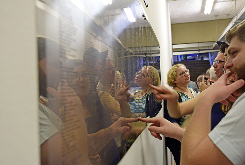 Memorial em homenagem aos ex-alunos Jovens apontam para placa em homenagem aos alunos do instituto de física