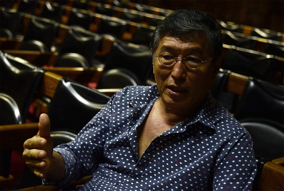 Miguel Chikaoka fala sobre a luz Homem em primeiro plano, sentado em auditório, gesticula