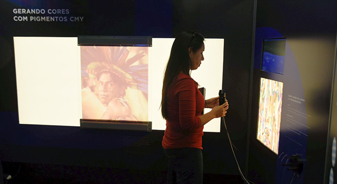 Visitante mulher observa painel da exposição Cor da Luz, do Museu Exploratório de Ciências