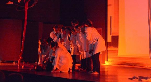 Imagem mostra encenação no auditório da Faculdade de Ciências Médicas da Unicamp.  Encenação do espetáculo "Nós", criado por alunos da unidades, mostra palco a meia luz e atores ao centro do palco