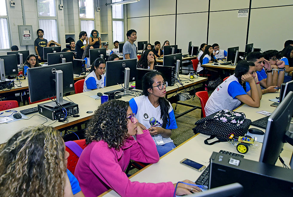 Alunos em frente aos computadores durante a aula da oficina de robótica