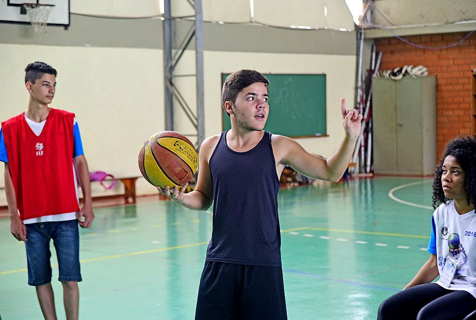 Laércio e o início do jogo O monitor Laércio dando início a partida de basquete adaptado, está em pé com a bola nas mãos