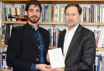 Gustavo, em 2014, em Nova Iorque, recebendo uma cópia autografada do livro de Michael Doyle, seu supervisor na Columbia University