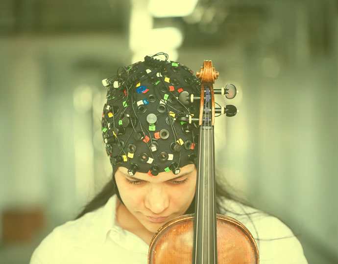 Pesquisadora da UFABC com touca usada para registrar as atividades cerebrais enquanto pratica música Pesquisadora da UFABC com touca usada para registrar as atividades cerebrais enquanto pratica música