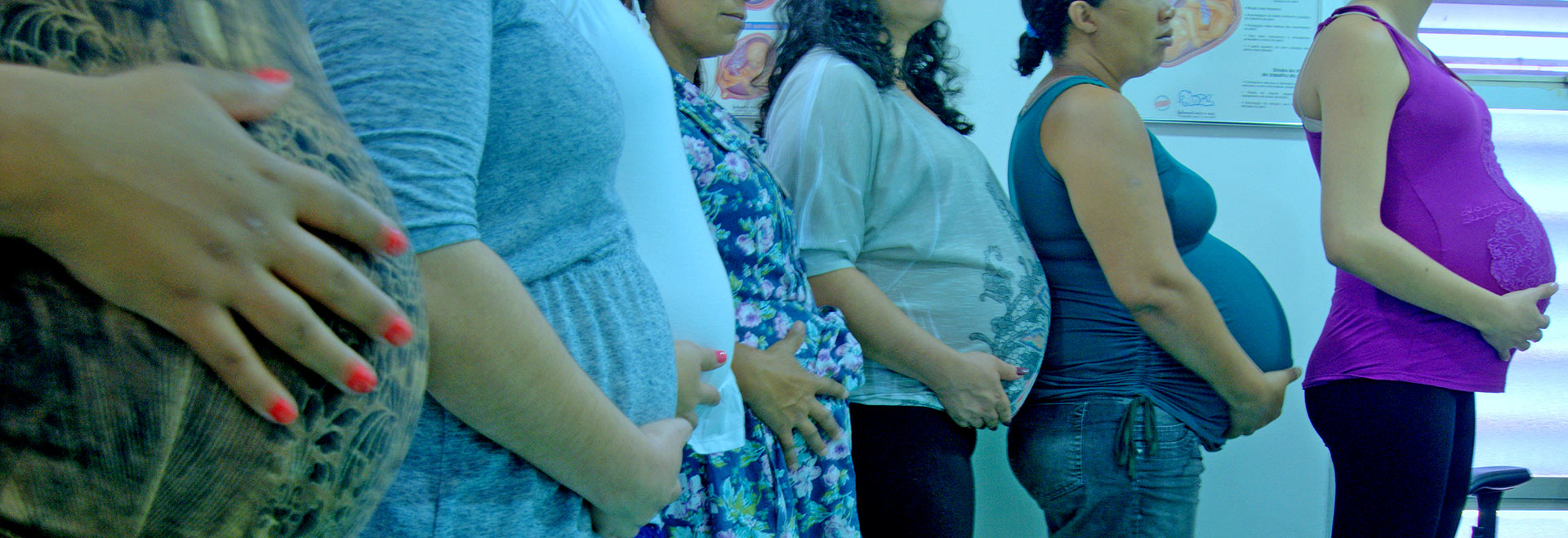 foto mostra mulheres grávidas enfileiradas, com suas barrigas em destaque