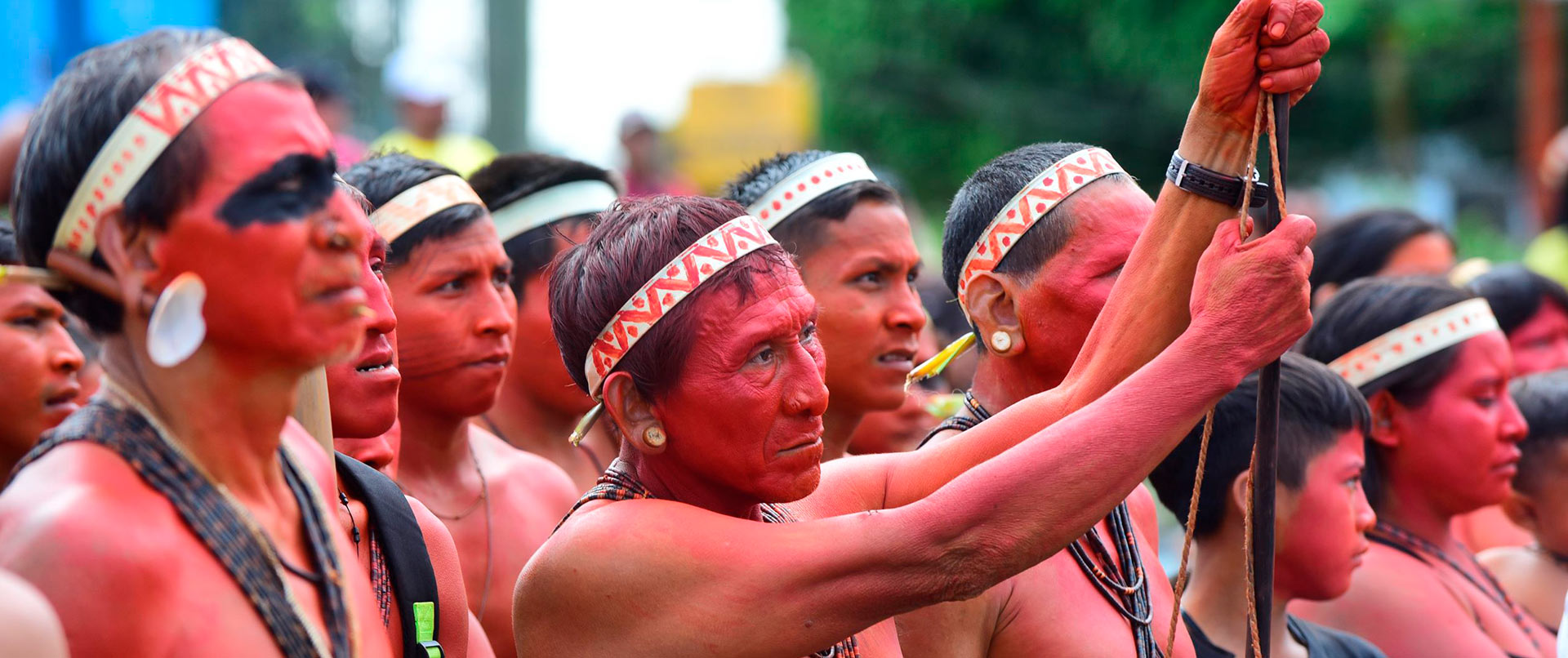 audiodescrição: fotografia colorida de diversos indígenas matis, eles estão pintados de urucum, com a pele vermelha