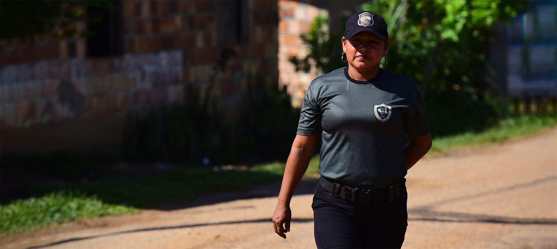 audiodescrição: fotografia colorida de uma das guardas indígenas; ela está uniformizada e caminha nas ruas da aldeia umariaçu