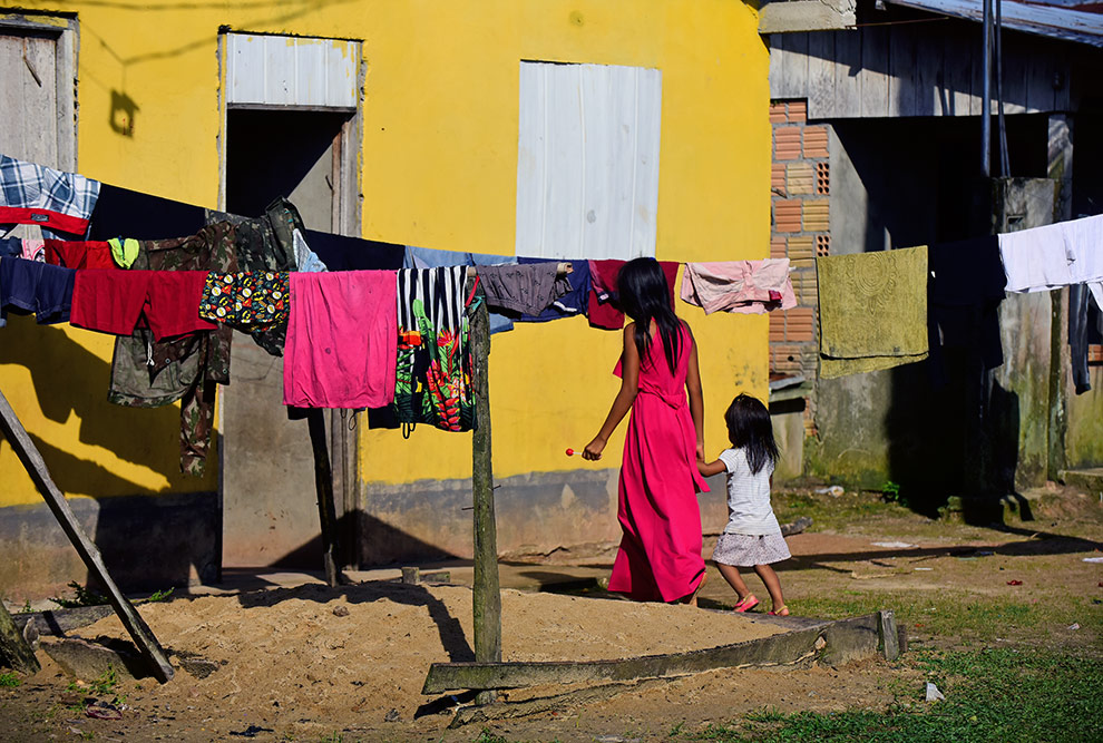 audiodescrição: fotografia colorida de moradoras da Umariaçu 2 caminhando na rua