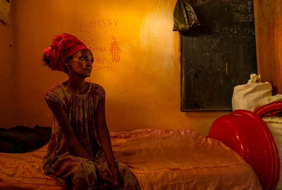 Mulher sentada em sua cama em uma escola transformada em campo de refugiados no centro de Mekelle; como ela, 200 mil pessoas fugiram das batalhas no Tigré (Etiópia, 2021)