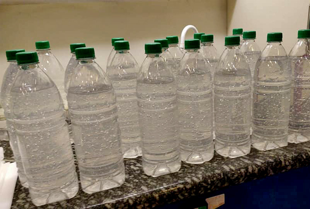 foto mostra garrafas de um litro com álcool em gel