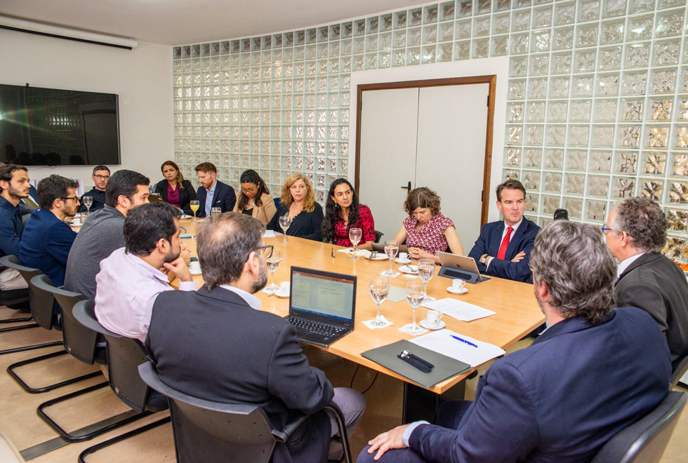 Foto ampliada mostrando todos os membros da reunião sentados em volta da mesa