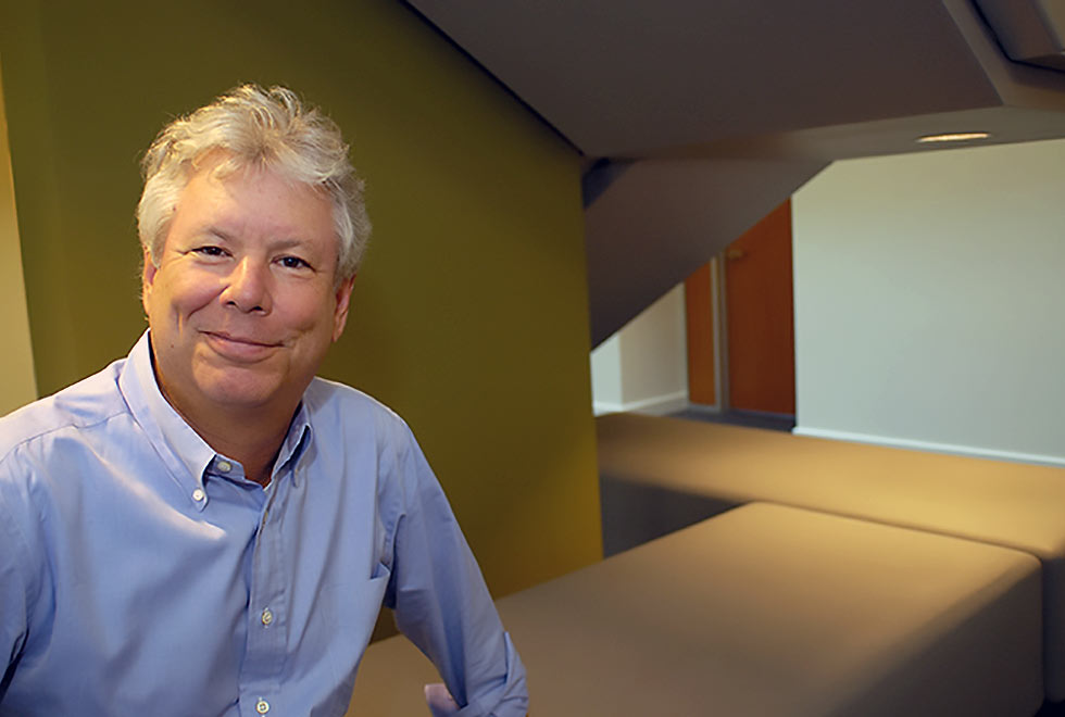 Richard Thaler, ganhador do Prêmio Nobel de Economia em foto de divulgação, veste uma camisa azul e sorri