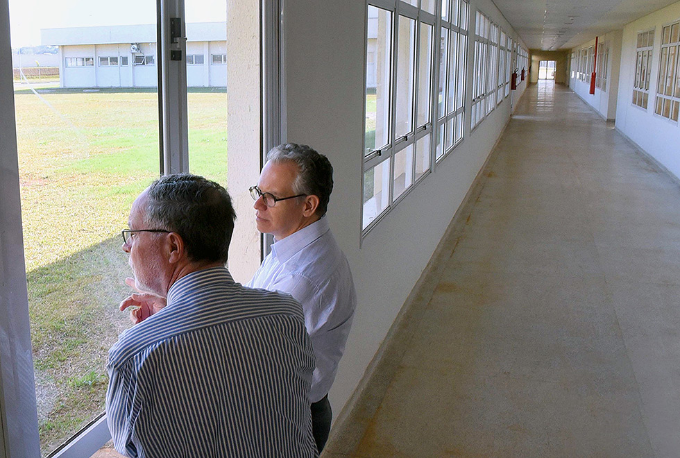 Knobel e Negri observam o lado de fora em uma das janelas do hospital