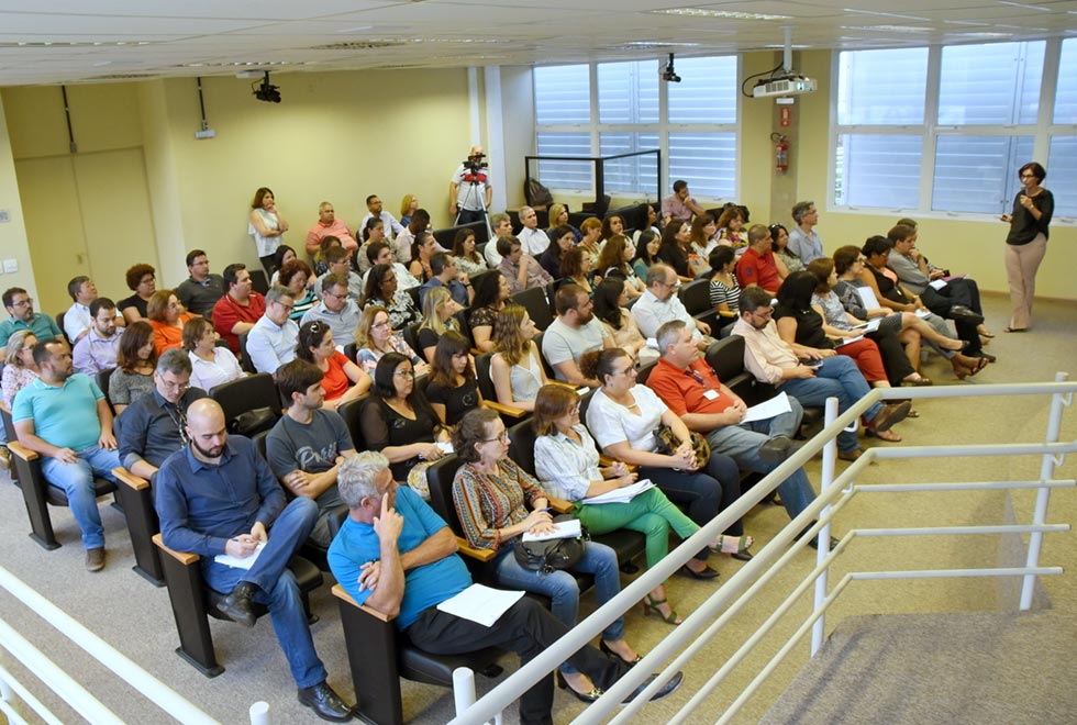 Participantes do encontro Gestão Estratégica: Processos e Desenho Organizacional, realizado no auditório da Educorp. Na foto, quase uma centena de participantes estão a esquerda da foto, acompanhando a palestra da professora Teresa Atvars, que está no palco a direita