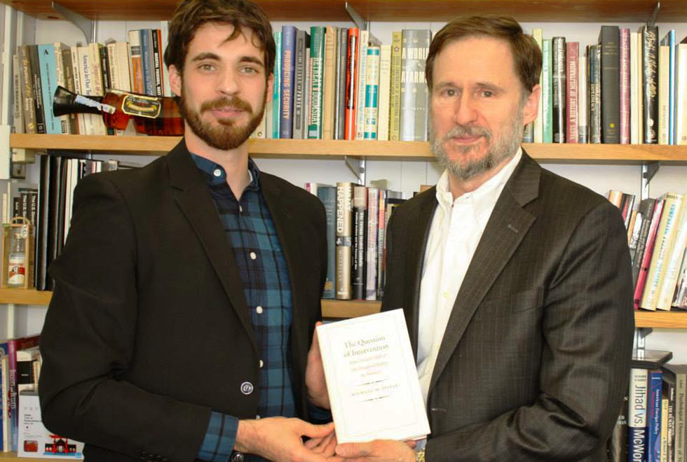 Gustavo, em 2014, em Nova Iorque, recebendo uma cópia autografada do livro de Michael Doyle, seu supervisor na Columbia University