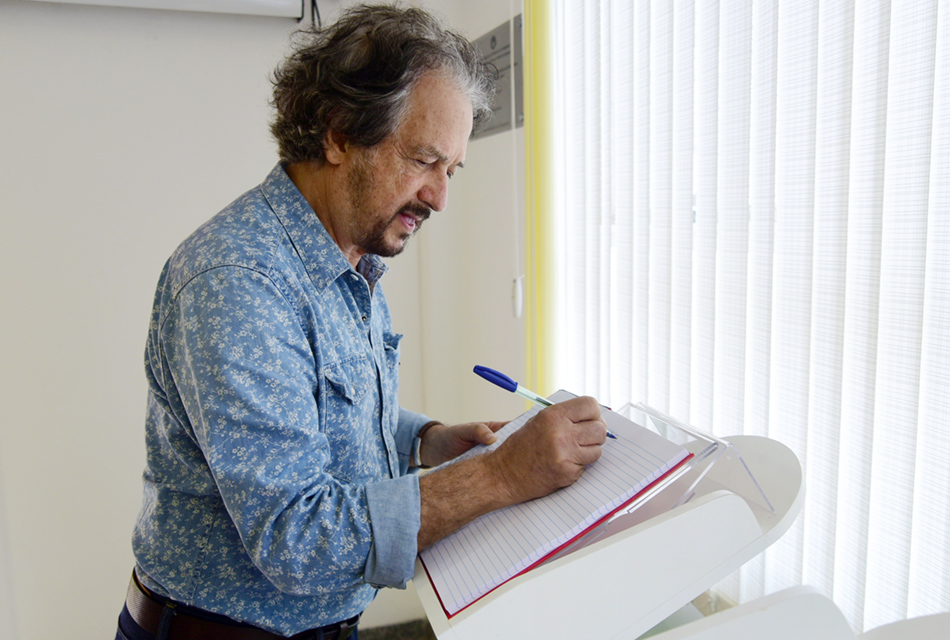 Claudio Tozzi assina livro de visitas de sua exposição na biblioteca do IFCH