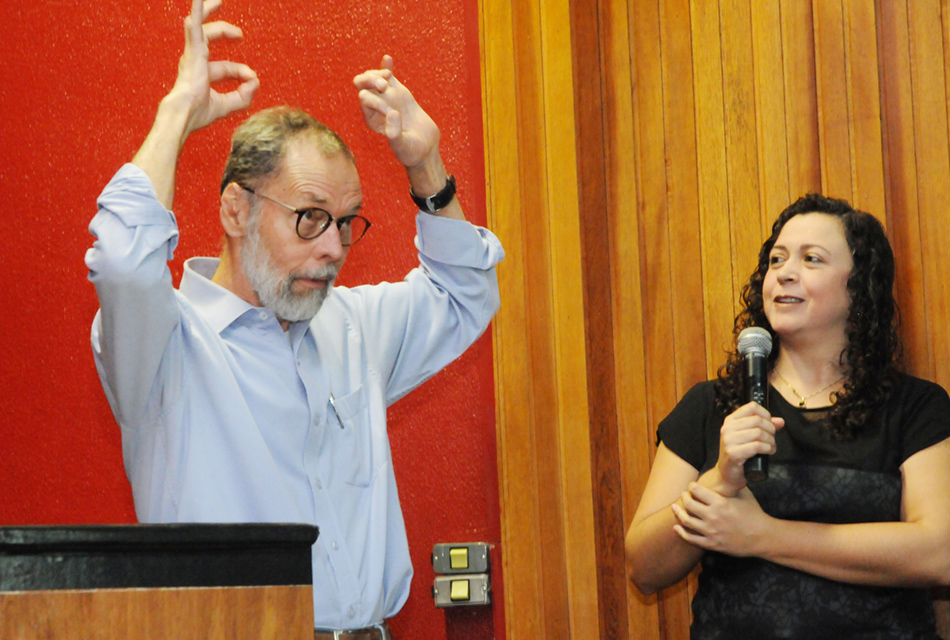 Professor inicia a palestra em Libras, ao lado da interprete que traduz ao microfone