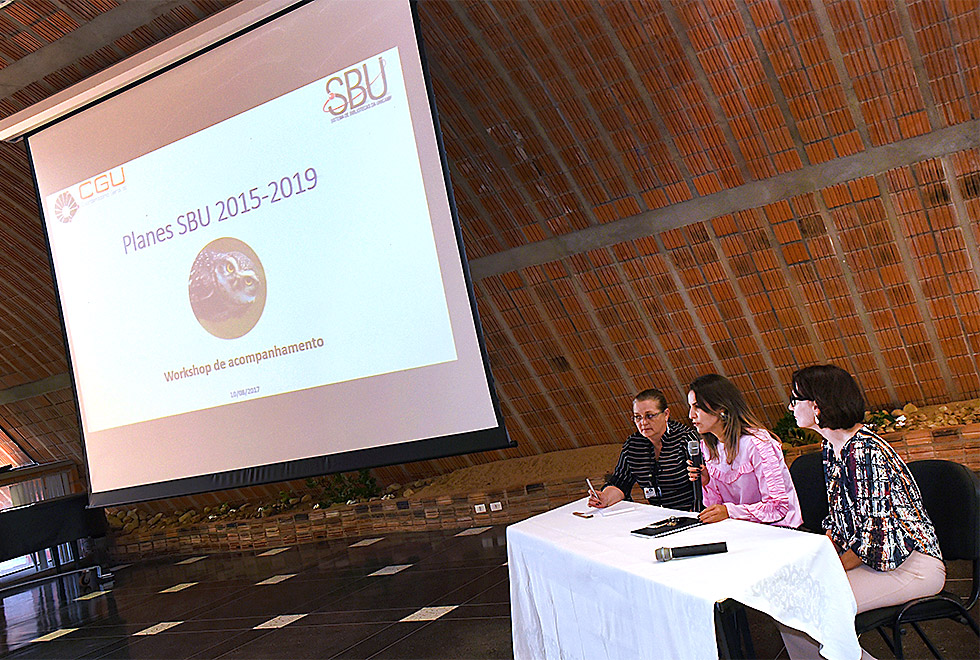 representantes da SBU estão sentadas em uma mesa em frente a um telão omde se lê worshop de aprimoramento