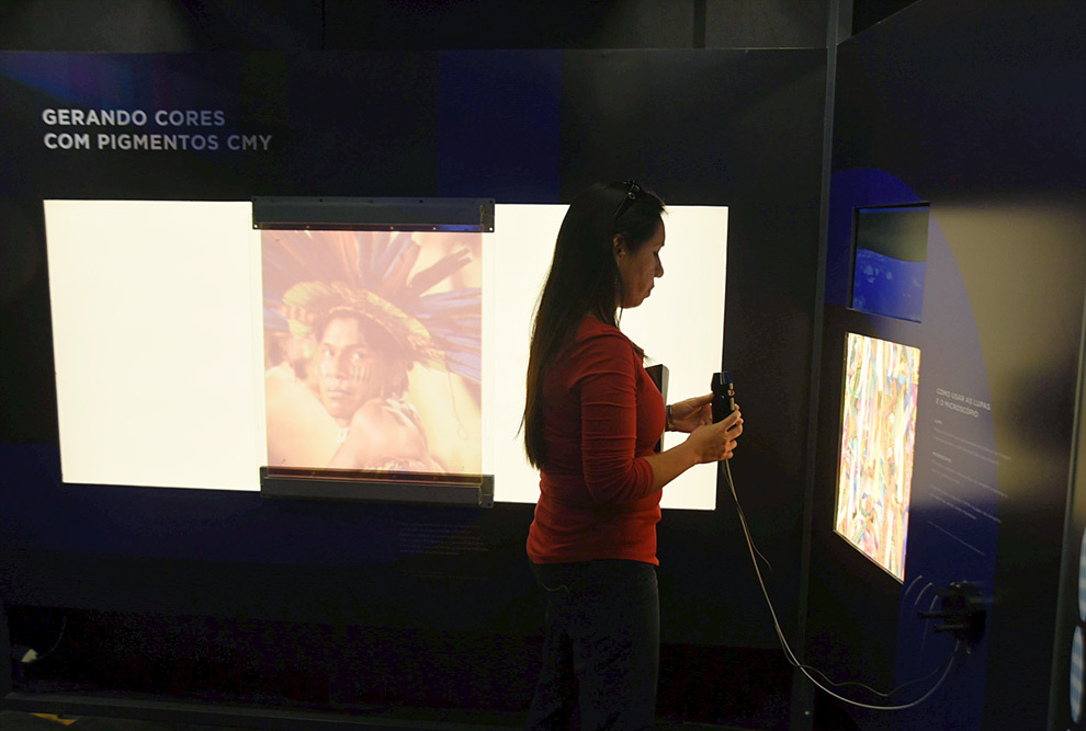 mulher interage com painel luminoso da exposição Cor da Luz