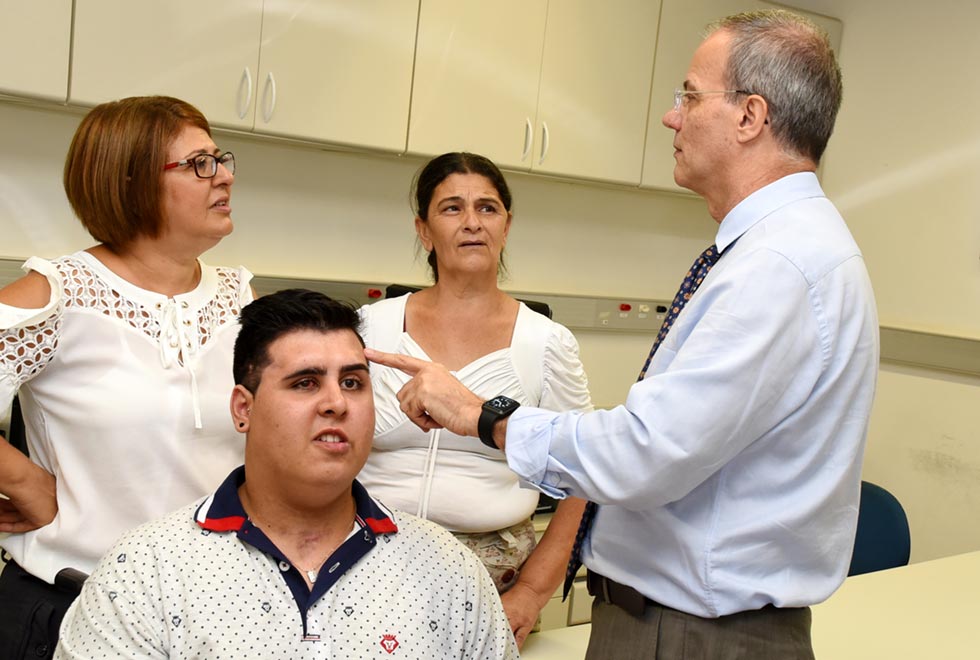 O cirurgião plástico do HC, Paulo Kharmandayan, conversa com pacientes e a mãe de Vinicius