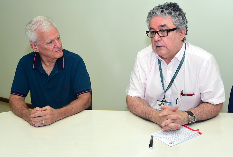 O estatístico José Carvalho e o médico José Guilherme Cecatti, sentados à mesa, falam à reportagem sobre o trabalho com a OMS