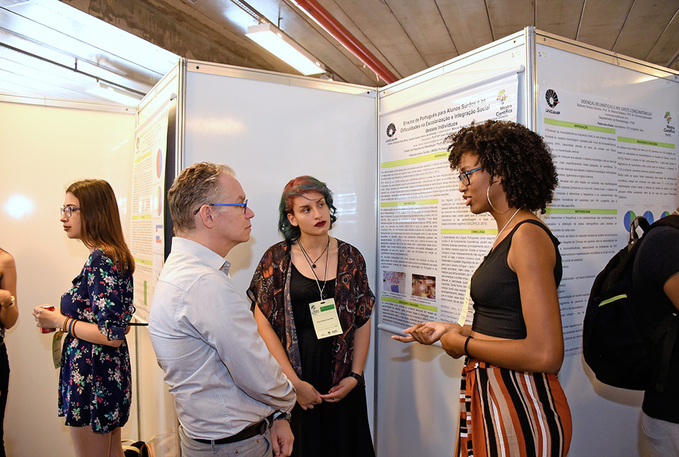 reitor ouve estudantes frente a poster