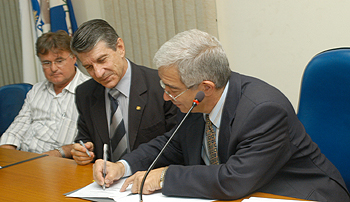 O coordenador geral da Unicamp, professor Fernando Costa (à direita), e João Luiz Pessa, da Cooperbio, assinam licenciamento (Foto: Antonio Scarpinetti)