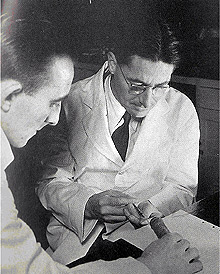 Florey (direita) e seu assistente Jim Kent, injetando penicilina em um camundongo na Universidade de Oxford (Foto: Divulgação)