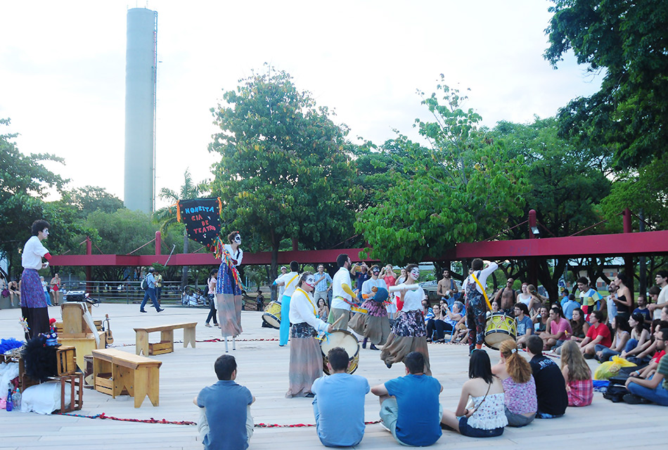grupo de estudantes sentado no chão assistem espetáculo teatral na Praça do Ciclo Básico