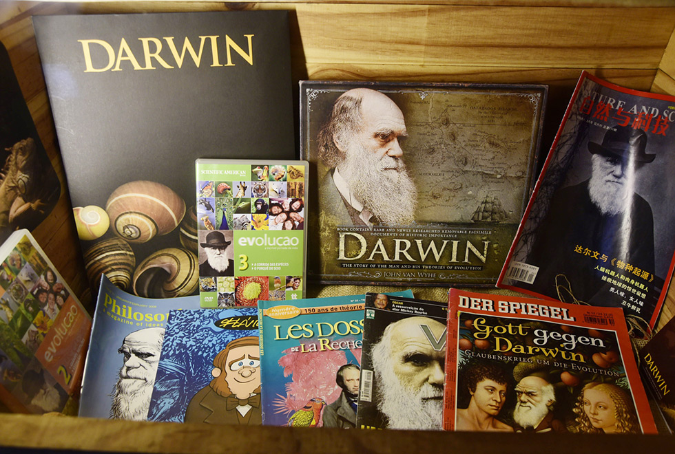 Diversas revistas e publicações sobre Darwin estão dentro de outro caixote iluminado