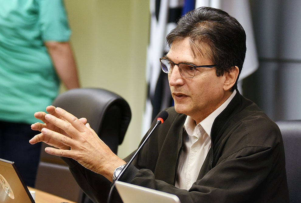 O pró-reitor André Furtado vai se reunir com coordenadores dos programas de pós-graduação O pró-reitor André Furtado com as mãos apoiadas em uma mesa e falando ao microfone
