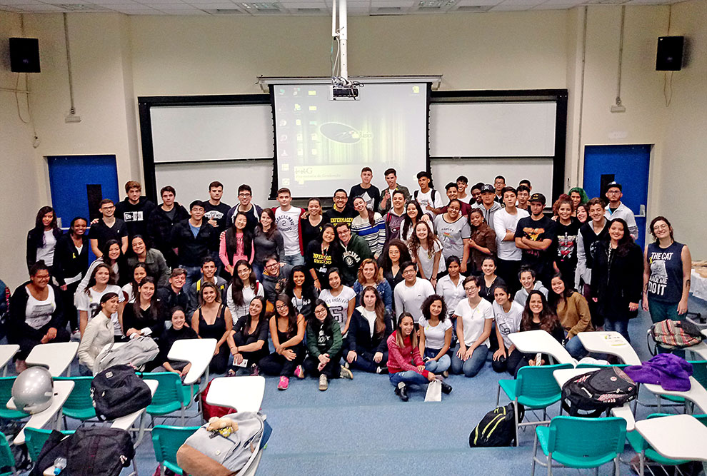 Voluntários e alunos do curso posam para a foto em sala de aula