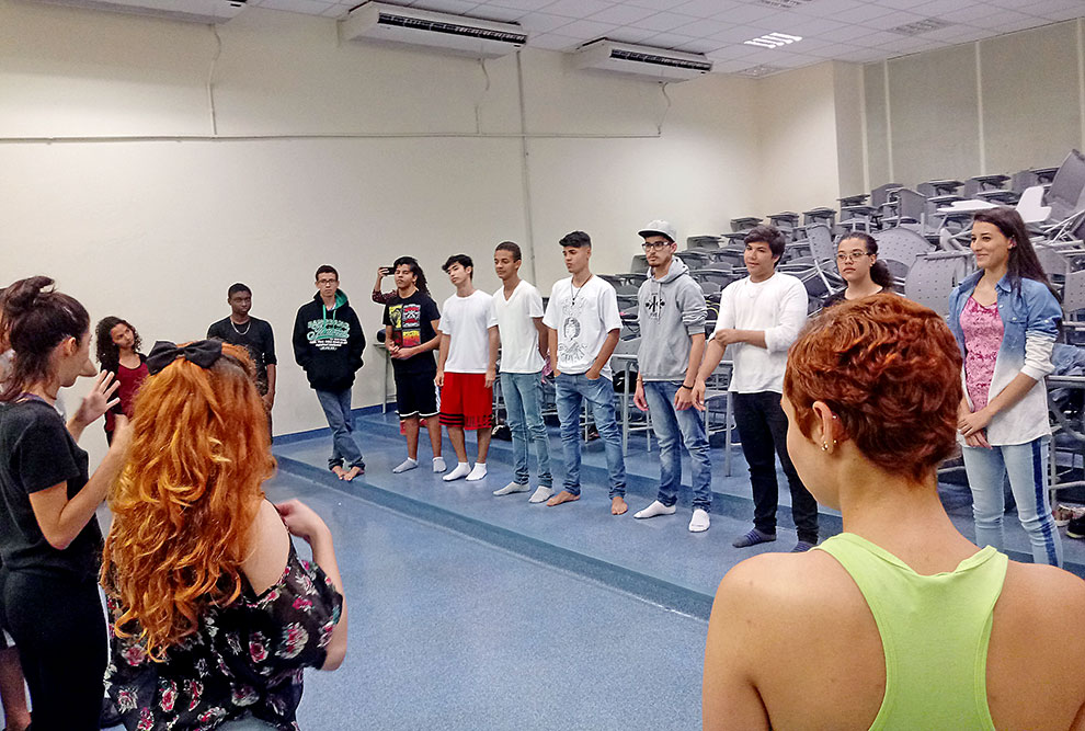 Alunos em círculo fazem exercícios em atividades de dramaturgia