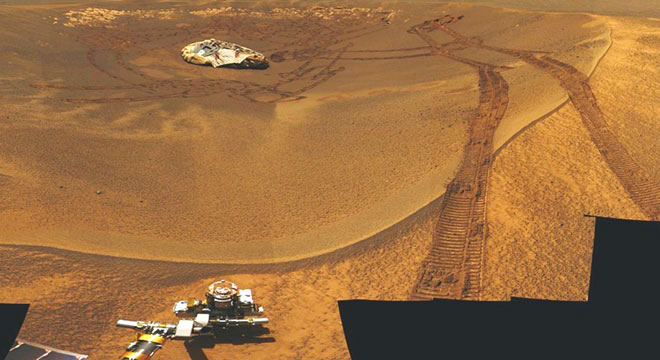 Foto da Cratera Eagle, local do pouso do Opportunity, tirada pelo próprio jipe. No interior da cratera encontra-se o dispositivo de aterrisagem e as marcas das rodas do jipe, após manobrar para sair do interior da cratera e iniciar sua jornada (NASA/JPL). Foto da Cratera Eagle, local do pouso do Opportunity, tirada pelo próprio jipe. No interior da cratera encontra-se o dispositivo de aterrisagem e as marcas das rodas do jipe, após manobrar para sair do interior da cratera e iniciar sua jornada (NASA/JPL).