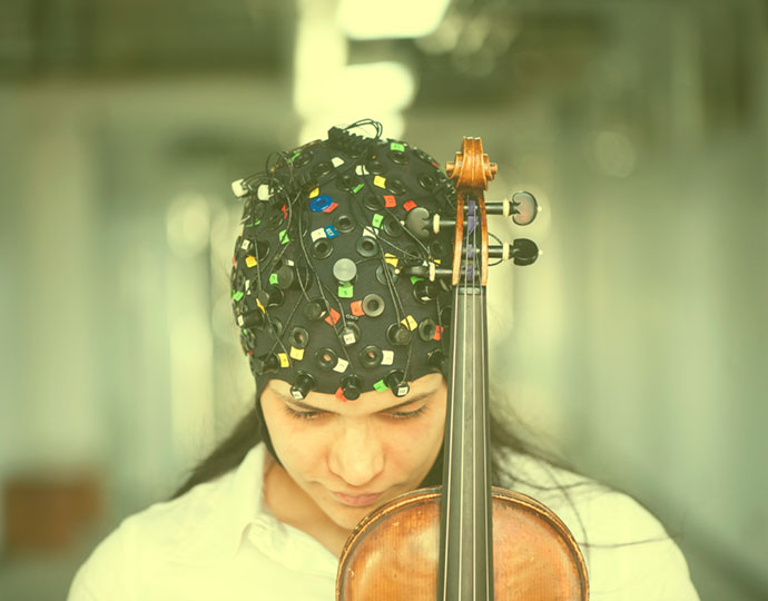 Pesquisadora da UFABC com touca usada para registrar as atividades cerebrais enquanto pratica música