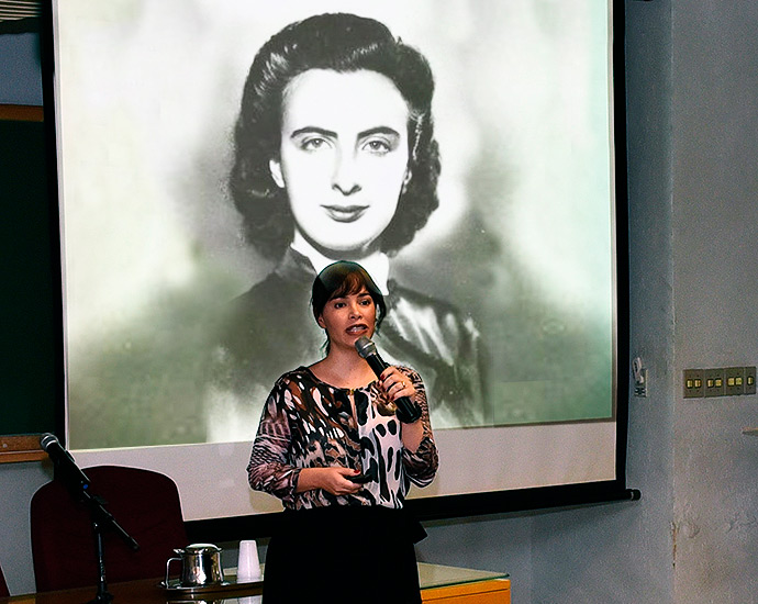Montagem mostra palestrante do grupo Elza com foto de Elza Gomide ao fundo