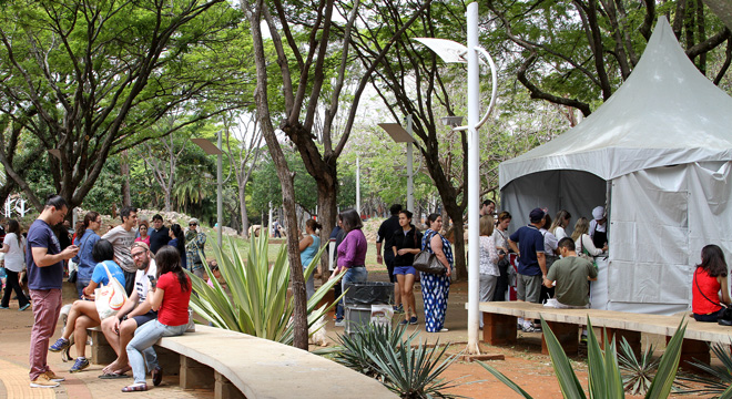 Foto da edição anterior do evento. Aparece uma das tendas e algumas pessoas sentadas