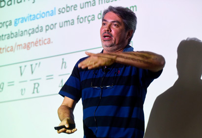 Professor dá palestra falando em frente a um telão