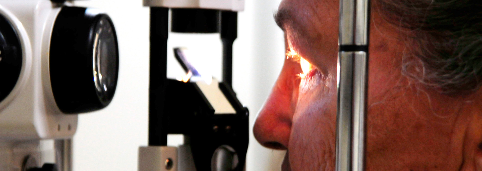 Oftalmologia do HC ganha maior prêmio mundial de visão. Foto: Antonio Scarpinetti Audiodescrição: em uma clínica de oftalmologia, imagem close-up e em perfil, homem faz exame de visão em equipamento, sendo que ele está à direita na imagem e com olhar voltado para a esquerda. À frente dele, à cerca de quinze centímetros de distância do rosto, equipamento com lente de vidro projeta feixe de luz no olho esquerdo do homem. Imagem 1 de 1.