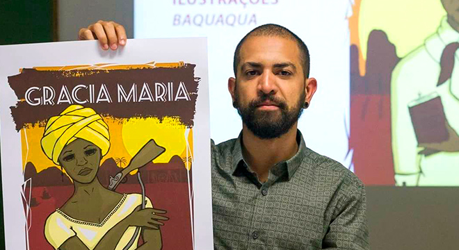 O designer e ilustrador paulista Pablo Parra com um cartaz da mostra