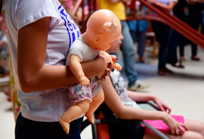 Uma boneca é segurada por uma criança que faz tratamento no Centro Boldrini