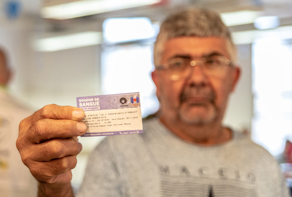 O auxiliar de produção José Roiberto Riva exibe sua carteirinha de doador