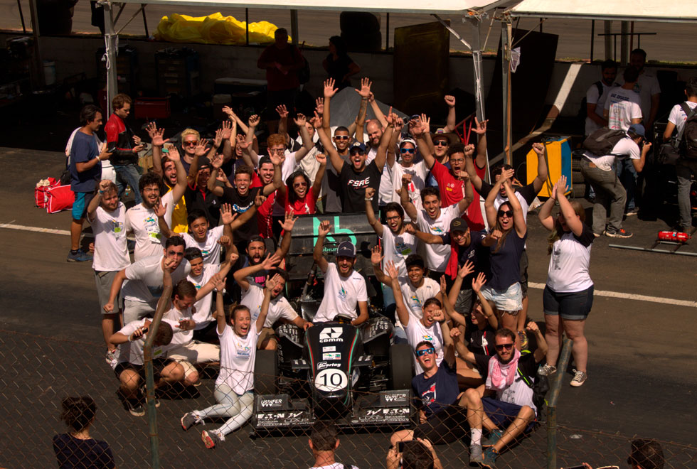 foto mostra membros da FSAE Unicamp reunidos em torno do carro comemorando a vitória