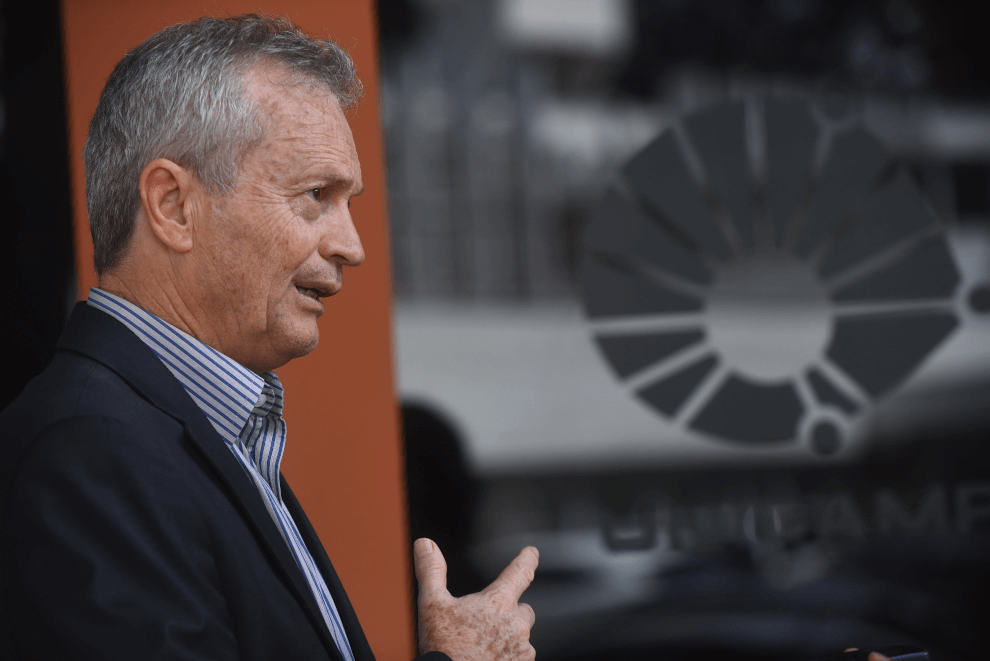 Diretor-executivo da Área de Saúde, Manoel Bértolo Audiodescrição: fotografia colorida mostra o diretor executivo da área de saúde de perfil em primeiro plano e ao fundo, o prédio da diretoria.
