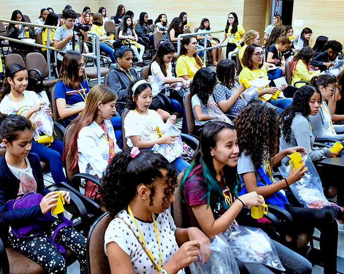 Segunda edição do Meninas SuperCientistas audiodescrição: fotografia colorida do auditório do Instituto de Computação; na plateia, lotada, estão jovens meninas