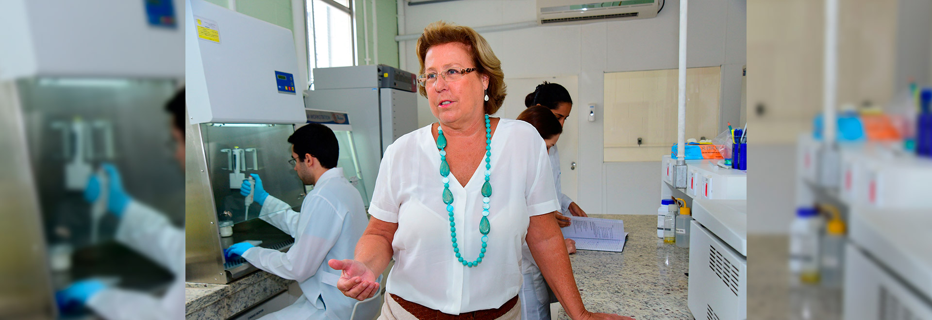 Professora Clarice Arns audiodescrição: fotografia colorida da professora Clarice Arns, em laboratório. Clique enter para acessar.