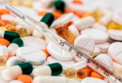 Foto de centenas de comprimidos de variadas formas e tamanhos dispostos em uma mesa 