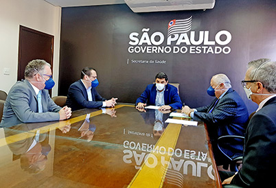 Reitor Marcelo Knobel em mesa de reunião com representantes da Secretaria Estadual de Saúde