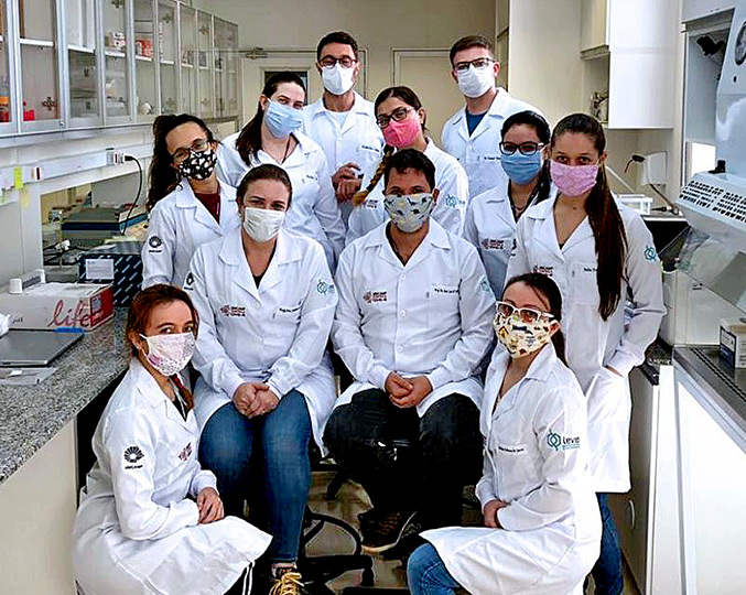 José Módena (à frente no centro, com máscara de dinossauros) com sua equipe no laboratório | Foto: Arquivo pessoal